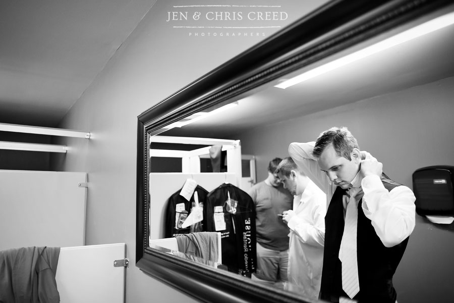 groom tying tie