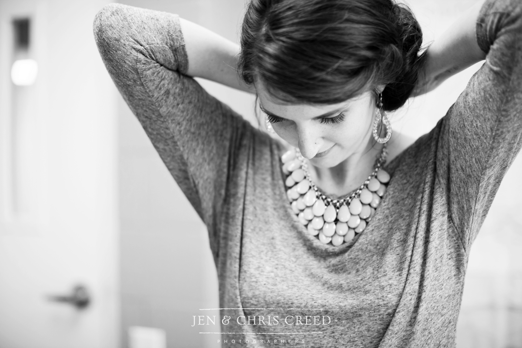 bride putting on necklace