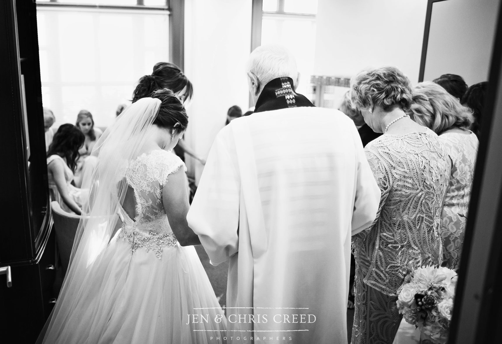 priest praying with bride