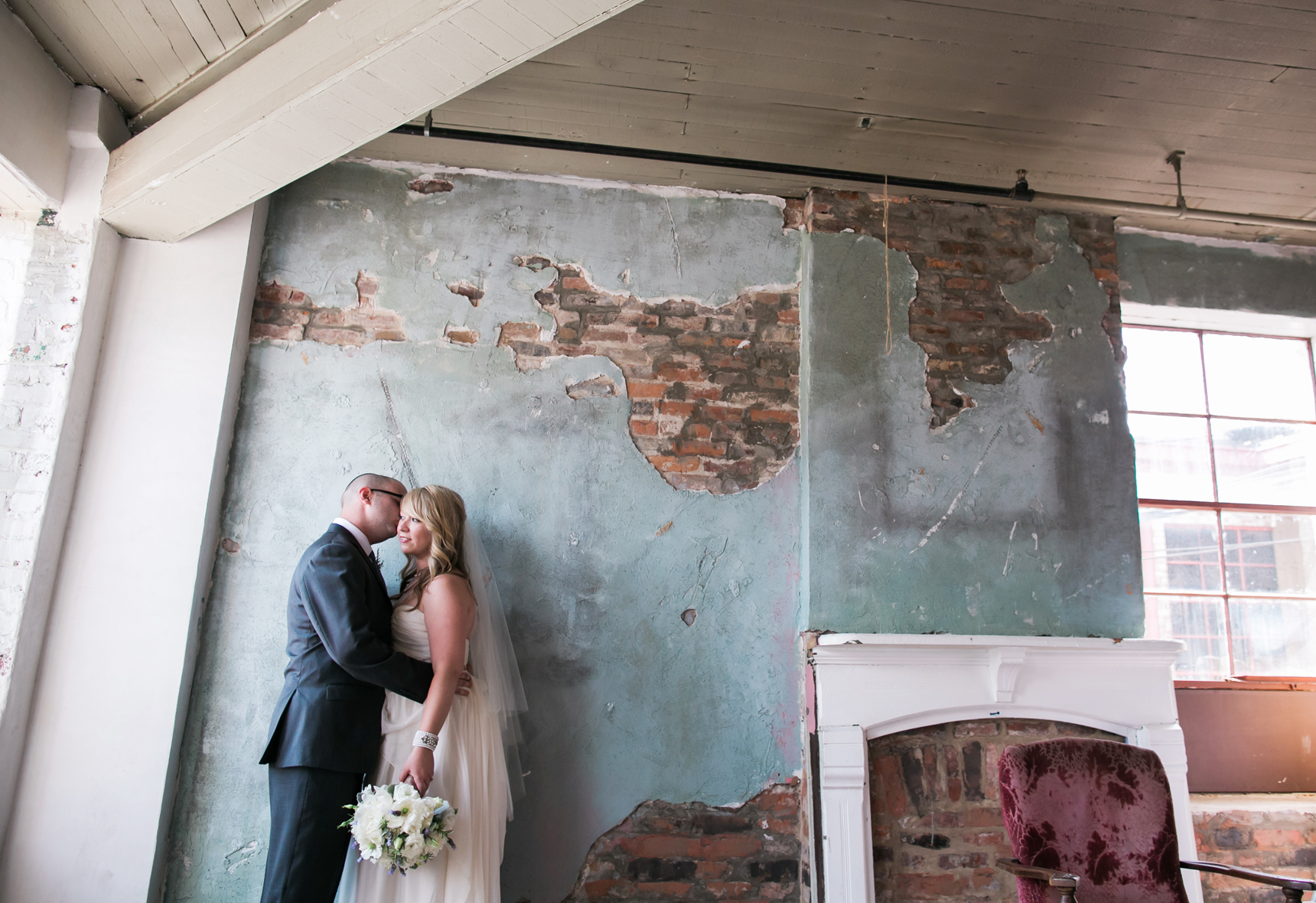 Bride and groom in front of blue wall