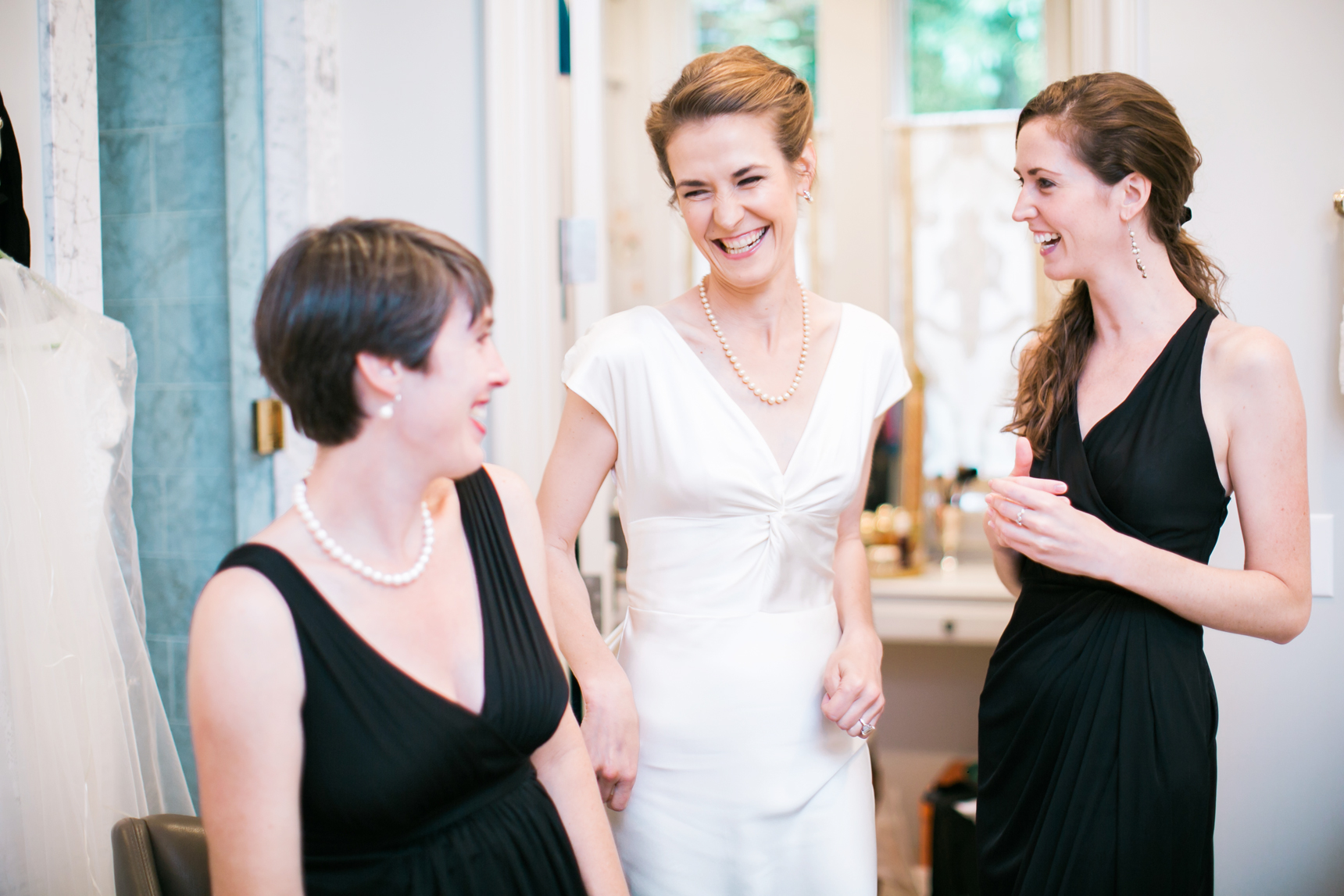 Bride laughing with sisters