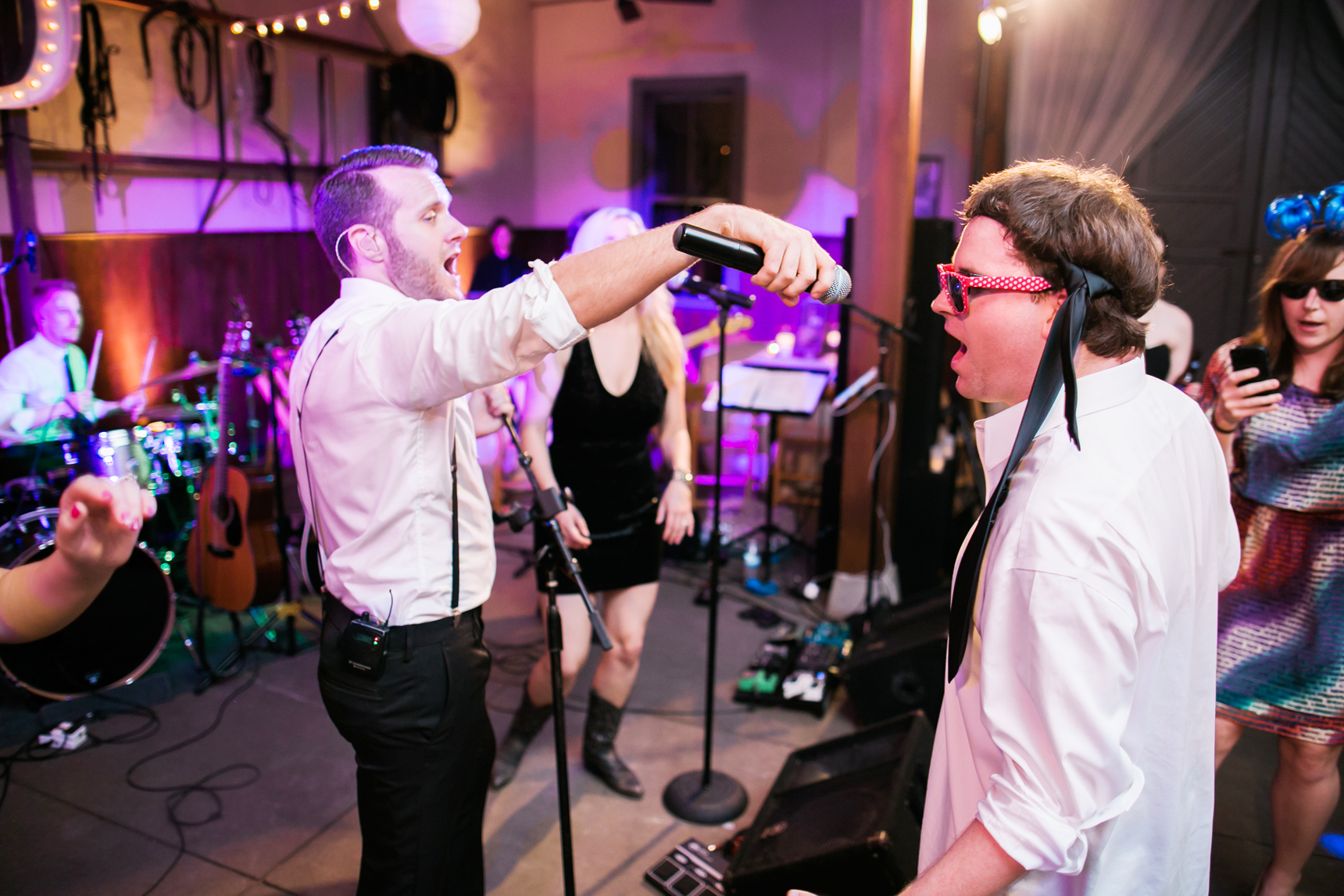 Groomsman singing with the band