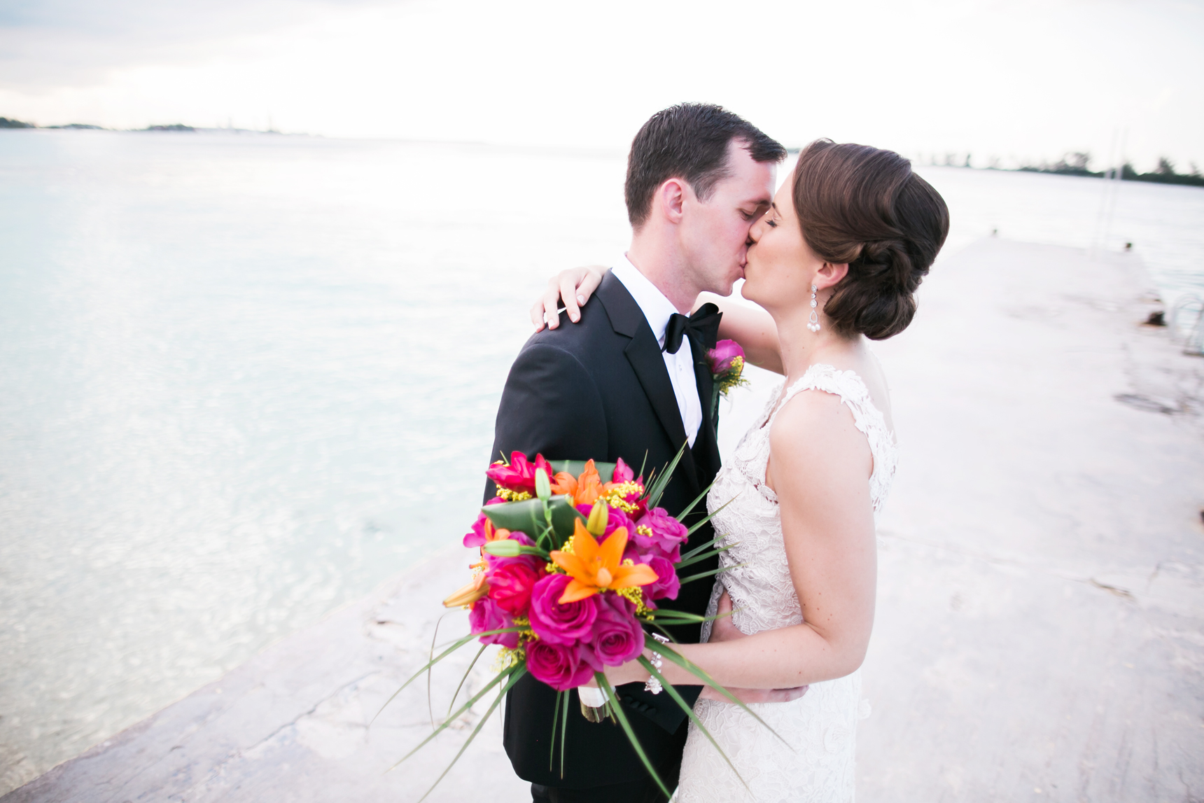 Bride and groom kissing on dock