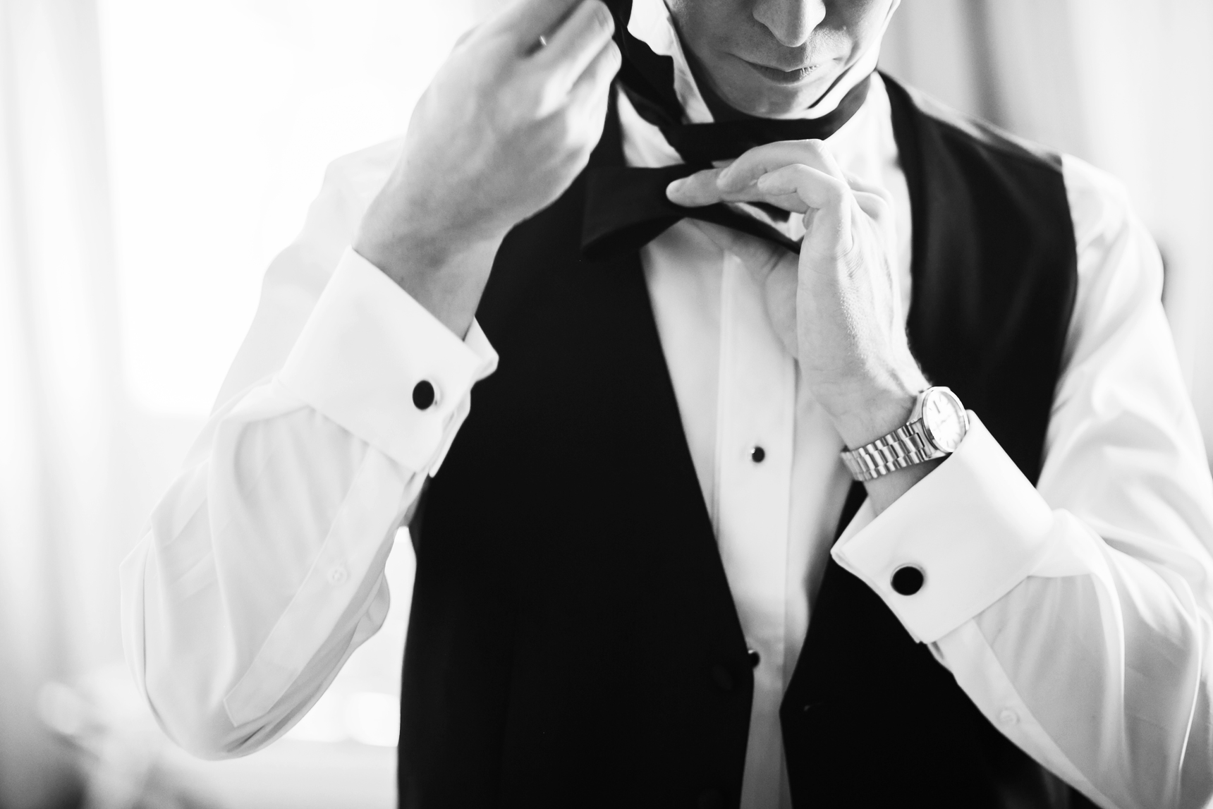 Groom tying bowtie