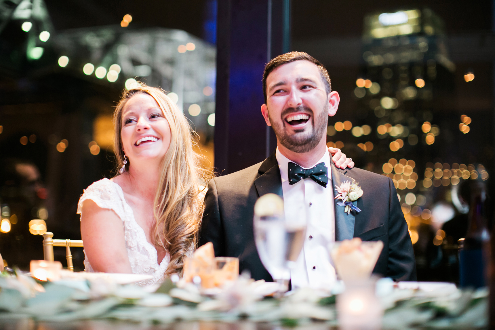Bride and groom laughing during toasts