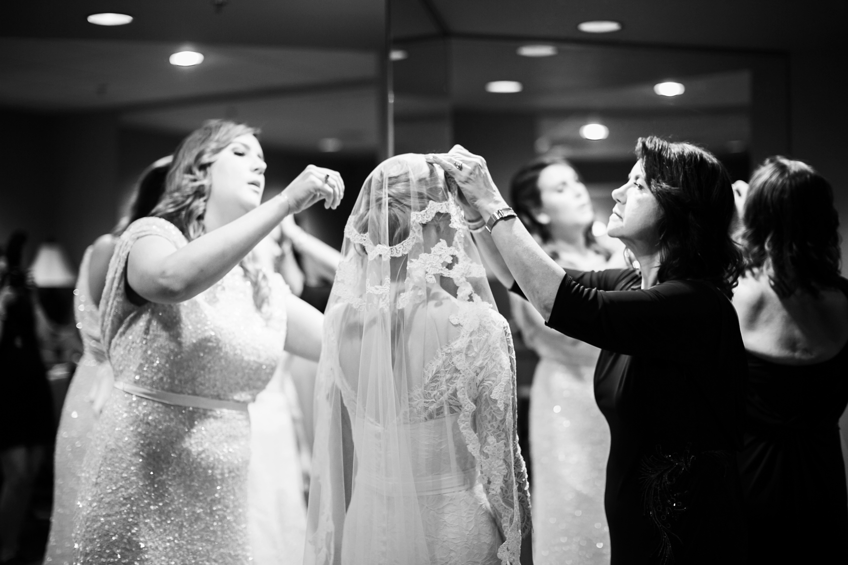 Mom and sister putting on bride's veil